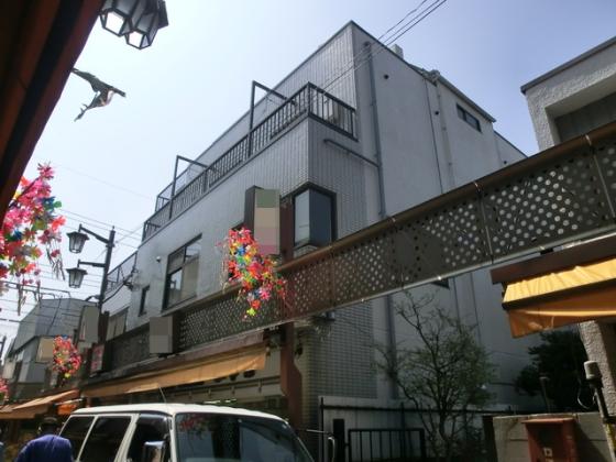 下町の商店街にあるマンションです。